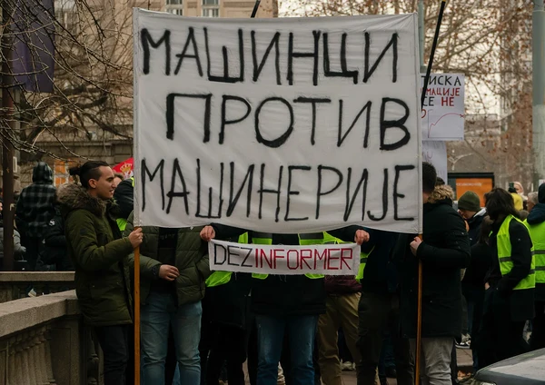 Студенти држе транспарент Машинци против машинерије и натпис Дезинформер
