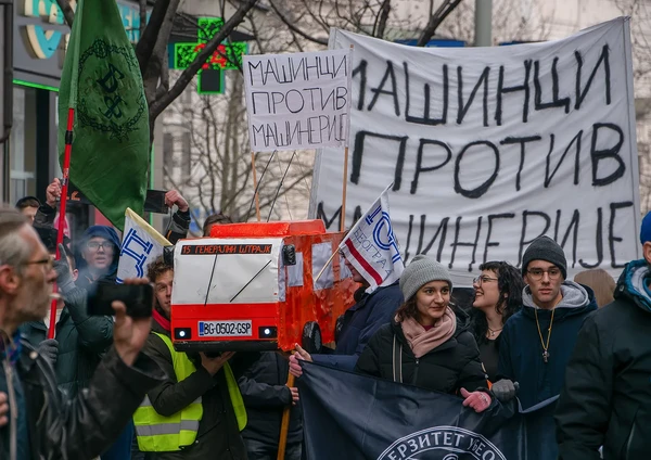 Студенти са макетом црвеног аутобуса и транспарентима Машинци против машинерије