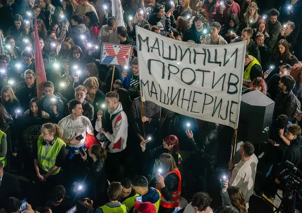 Ноћна маса са упаљеним лампицама телефона и транспарентом Машинци против машинерије