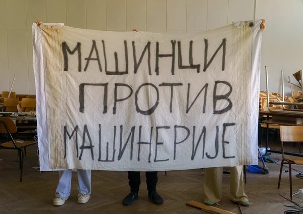 Студенти држе велики транспарент Машинци против машинерије у сали факултета