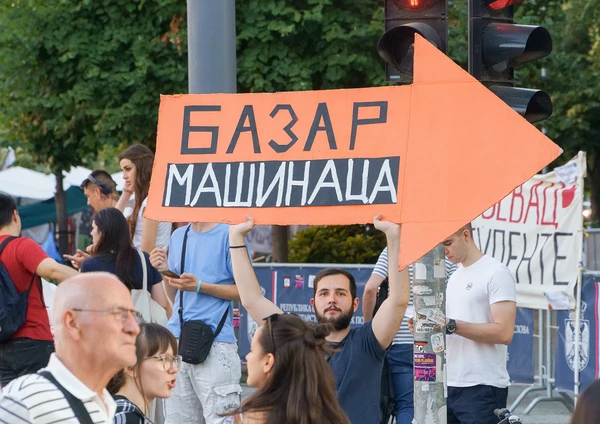 Студент држи наранџасту стрелицу Базар Машинаца